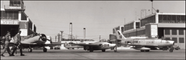 From l. to r.: Harvard trainer, Vampire jet fighter, and Sabre jet fighter, 400 Auxiliary Flying Squadron, Downsview, Ontario, March 1957. - DND RE 108089
