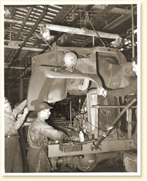 Des travailleurs montent un camion militaire dans une usine de la compagnie Ford du Canada Limite  Windsor (Ont.), novembre 1940. - Photo :  Office national du film
