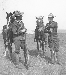 Boer War Photo, Two dismounted troopers from the 1st Battalion, Canadian Mounted Rifles in conversation on the South African veldt and shows the Western-Canadian influence. CWM AN 19650036-003