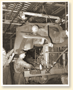 Des travailleurs montent un camion militaire dans une usine de la compagnie Ford du Canada Limitée à Windsor (Ont.), novembre 1940. - Photo : Office national du film