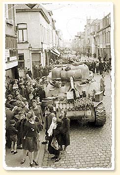 Sherman tank on a festive street with crowds - AN19900198-123