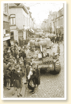 Sherman tank on a festive street with crowds - AN19900198-123
