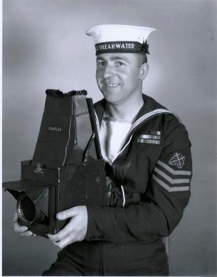 A Royal Canadian Navy Petty Officer 2nd Class holding a large