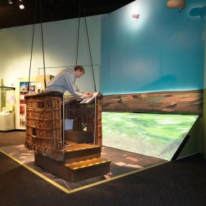 A young man interacting with an exhibition interactive