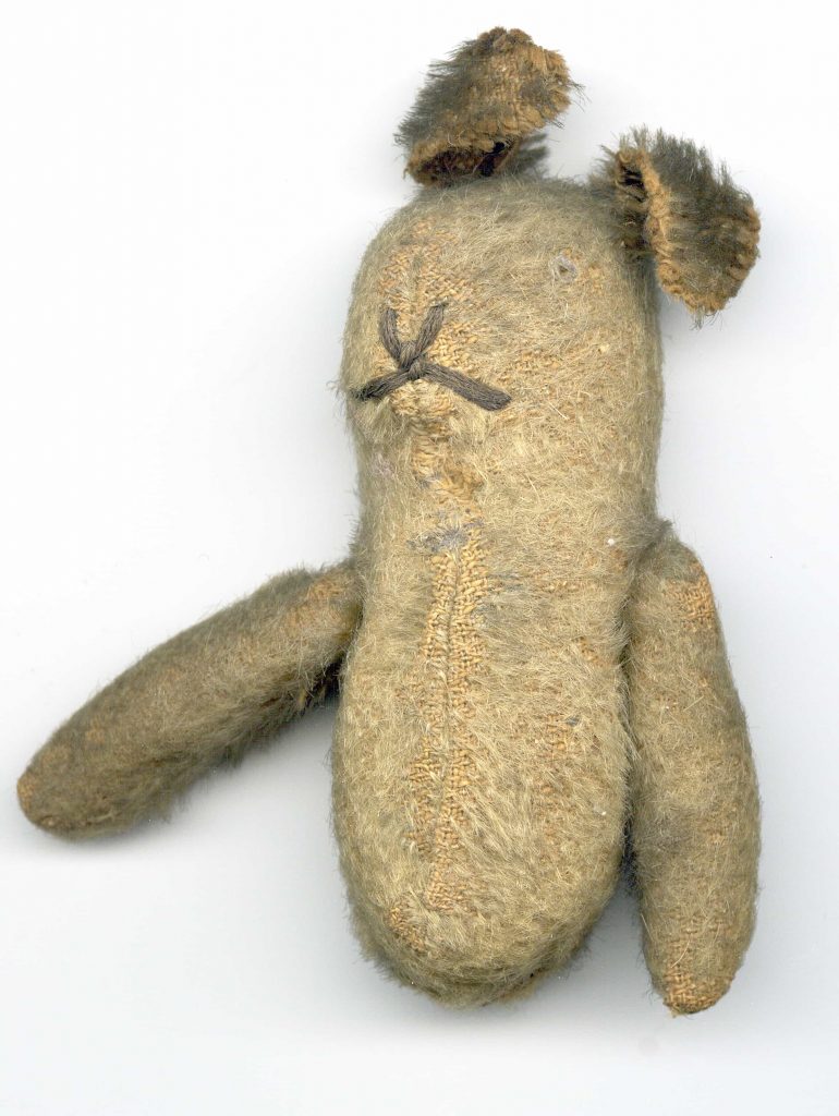 A teddy bear missing its legs