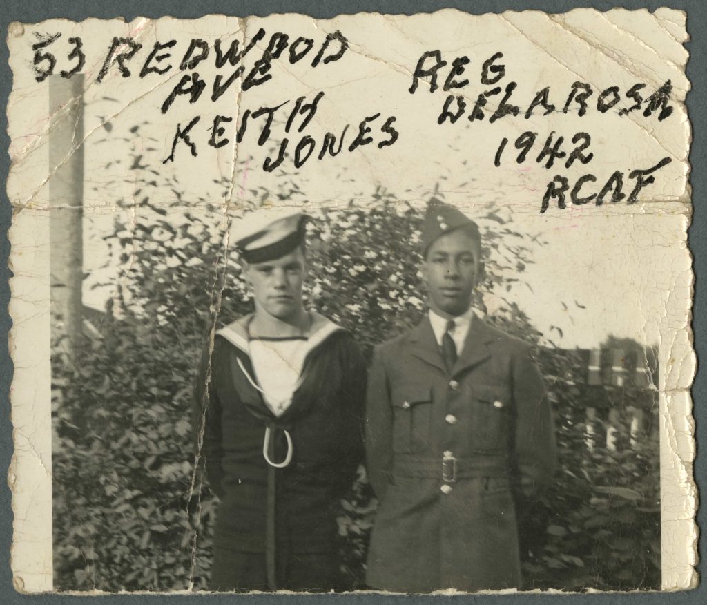 A white man in a navy uniform stands beside a Black man in an air force uniform. Handwritten text identifies the men.