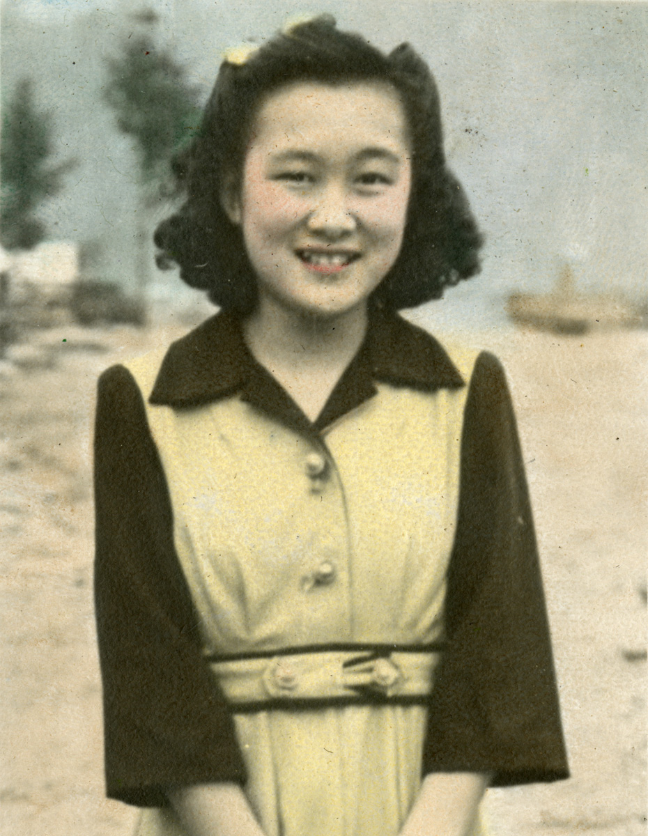 A woman in a yellow dress is smiling at the Canadian War Museum.