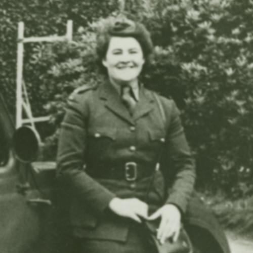 A woman in uniform sitting next to a car at the Canadian War Museum in Ottawa.