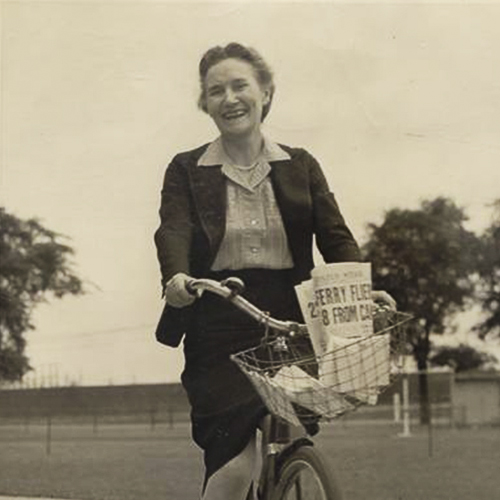 An old photo of a woman riding a bicycle with a basket in Ottawa.