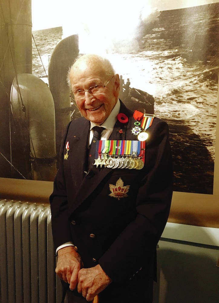 A man in a military uniform standing in front of a picture at the Canadian War Museum in Ottawa.