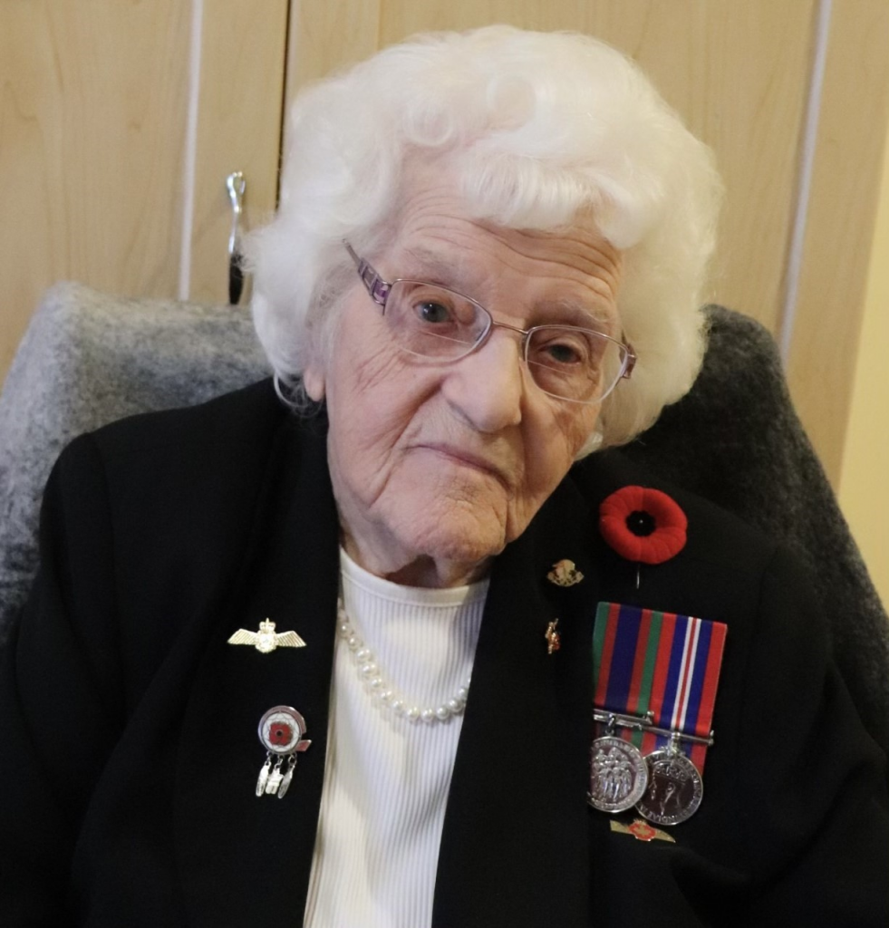 An older woman sitting in a chair with medals at the Canadian War Museum in Ottawa.