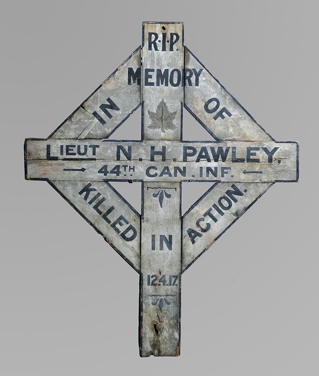 Wooden cross grave marker with details of deceased written on it.