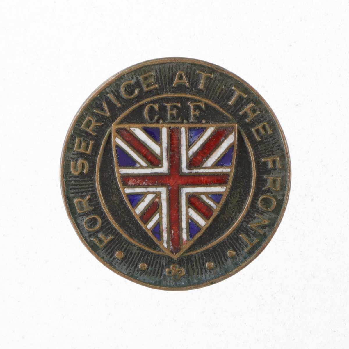 A round metal pin that reads “For Service at the Front, C.E.F.” around the outside, with a Union Jack flag on a Tudor shield in the centre.
