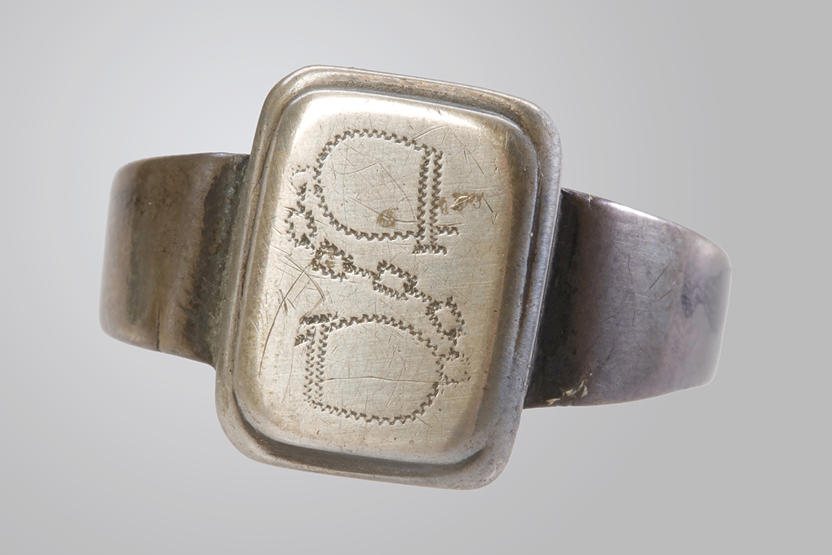 Close-up of a silver ring with engraving.