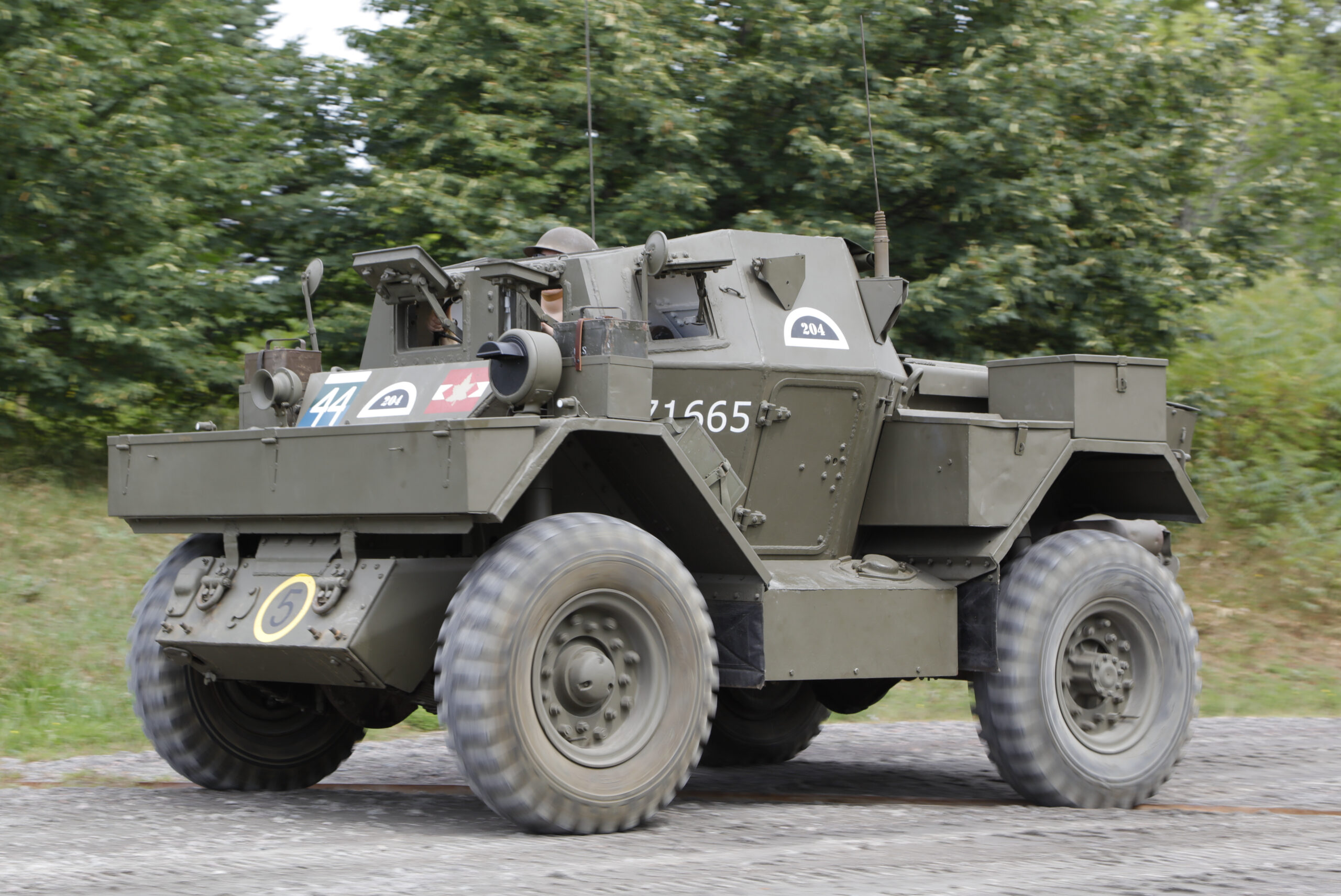 A small, green armoured vehicle with wheels and numerous radio antennas.