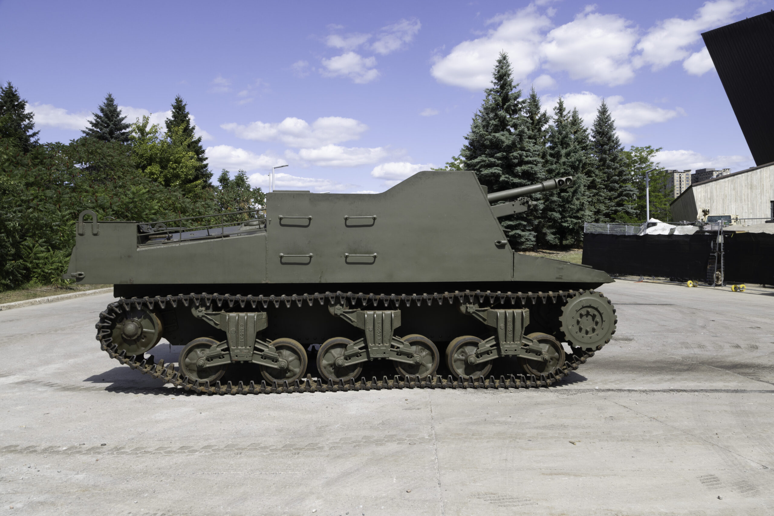 A green military tank with high, square armoured sides and a large forward-facing main gun.