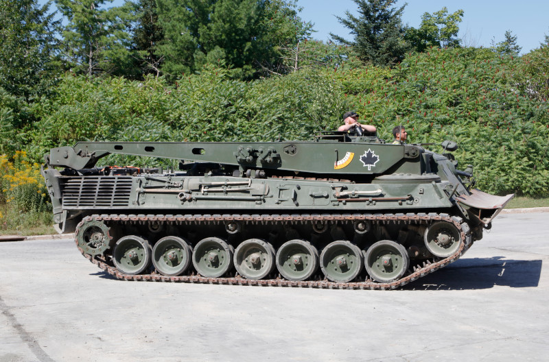 A long, tracked armoured vehicle with a large folded-down metal structure on top.
