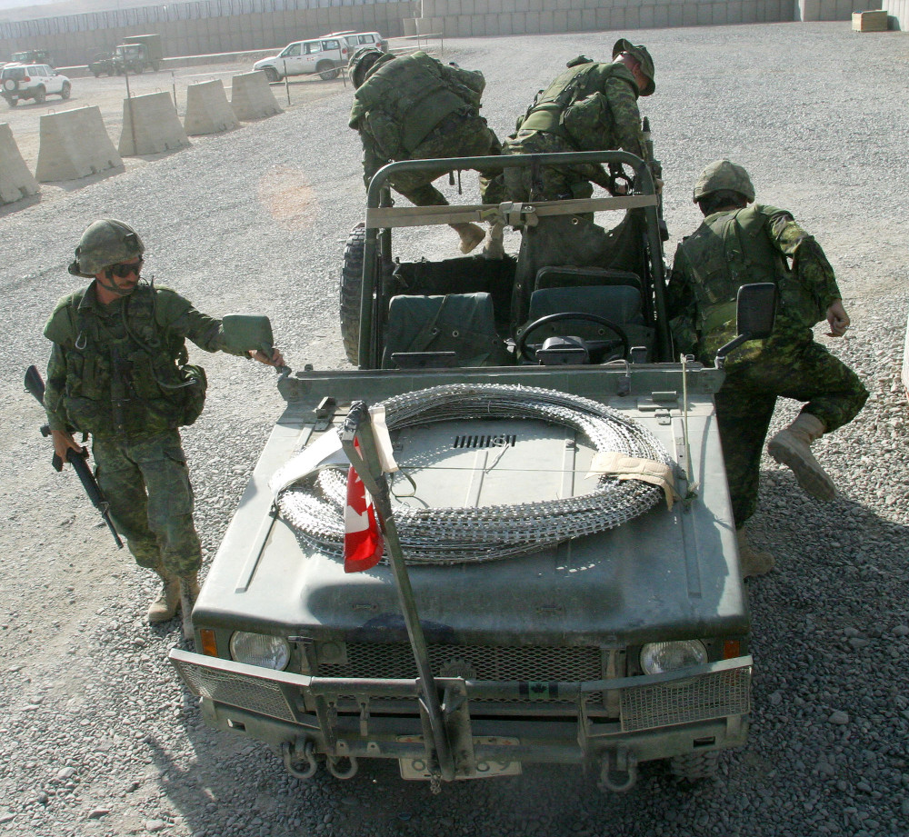 Four soldiers simultaneously climb in all directions out of a Jeep-like vehicle with an open top and sides