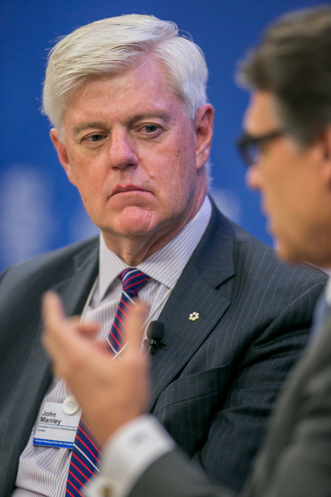 A light-skinned person with short grey hair wearing a striped jacket and tie.